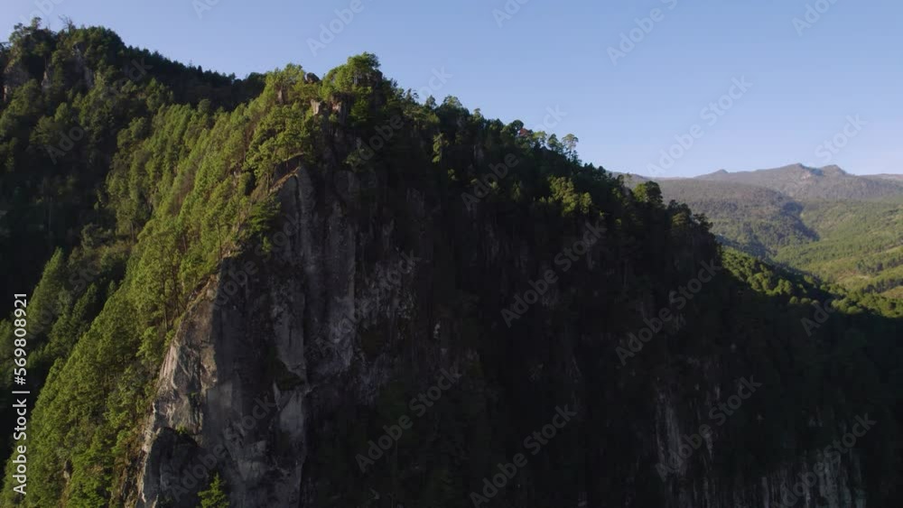 Aerial video of a drone traveling across a hill revealing a mountain Aerial video of a drone traveling across a hill revealing a mountain
