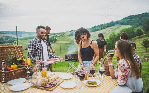 Group of friends spending time making a picnic and a barbeque photo