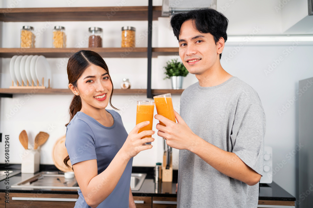 Happy Asian couple enjoy drinking healthy vegan smoothie in the kitchen counter. Couple making vegan smoothie together at home for a healthy lifestyle. Happy Asian couple enjoy drinking healthy vegan smoothie in the kitchen counter. Couple making vegan smoothie together at home for a healthy lifestyle.