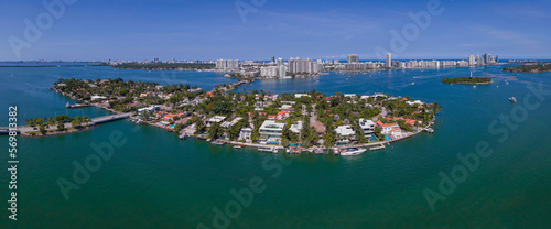 Intracoastal Waterway with waterfront homes and buildings in Miami Florida. Aerial view of a man-made inland water channel with city skyline against blue sky.