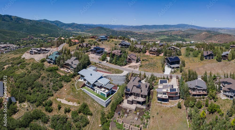 Aerial view of beautiful mountain houses on a sunny day in Park City Utah. Residential neighborhood landscape surrounded by trees and scenic nature views.