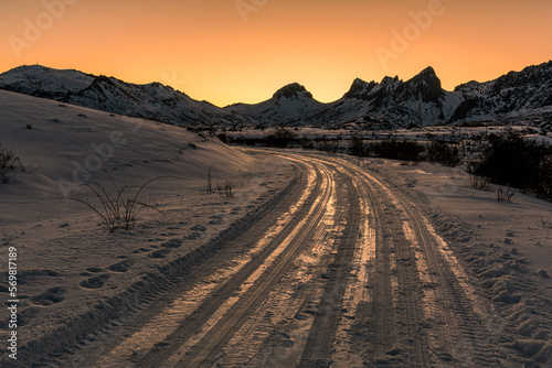 Track on the snow towards the Casares Reservoir and Peñas de Cubillas de Arbas in the background at sunset, León, Spain.