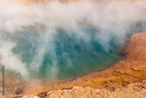 Steaming hot spring with colored travertine deposits at the El Tatio geyser field in the high Andes of northern Chile 
