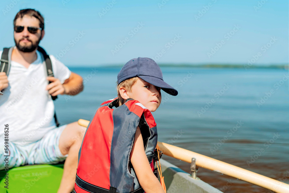 caucasian bearded man and litle boy floating on rowboat in lake