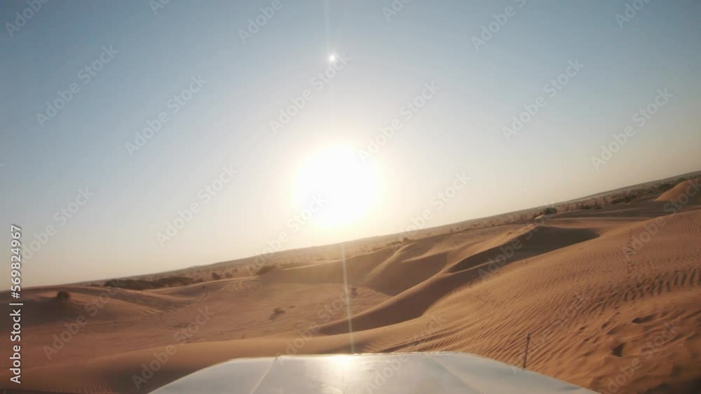 4K POV of a vehicle dune bashing on the sand dunes of the Thar desert at Jaisalmer in Rajasthan, India. Car moves on the desert during the day. Extreme adventure in the desert background.