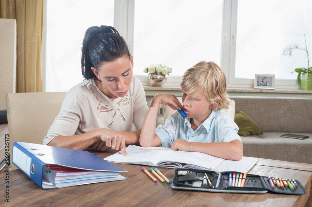 Woman helping her son with his homework, Bavaria, Germany Woman helping her son with his homework, Bavaria, Germany