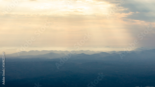 Landscape of sunbeam shining on blue mountain range.