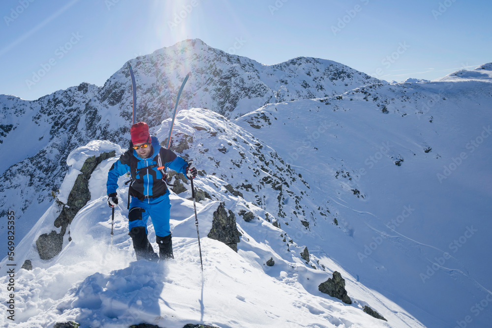 Skier walking on ridge of snow mountain Skier walking on ridge of snow mountain