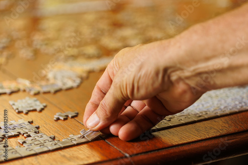 mans hand placing jigsaw puzzle piece
