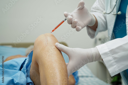 Asian doctor inject Hyaluronic acid platelet rich plasma into the knee of senior woman to walk without pain. photo