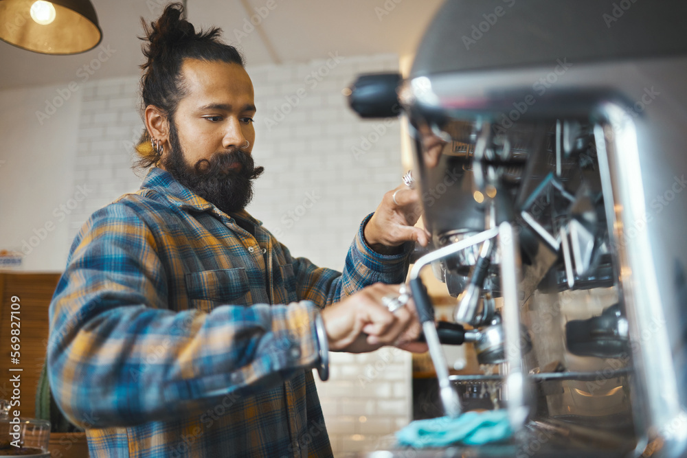 Man in coffee shop, barista working machine and create drink with focus and small business, workflow and process. Espresso, latte or cappuccino production, busy server in cafe and professional
