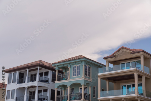 Low angle view of beach houses with balconies against the white giant clouds at Destin  Florida. Three modern beach houses architecture with balconies.