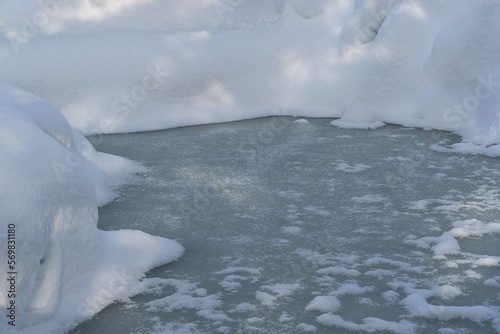 Snowy winter. Winter fairy tale. Magic garden pond under ice. Banks are covered with high snowdrifts. Atmosphere of relaxation, tranquility and happiness inwinter garden. Nature concept for design. photo