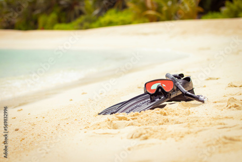 Swimming flippers and snorkeling mask laying on the beach in the sand