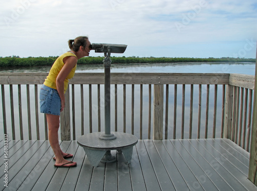 Woman exploring Florida wildlife refuge with spyglass