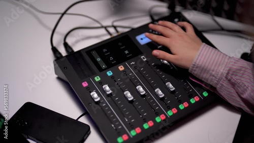 Crop of young woman operating a soundboard for podcast recording