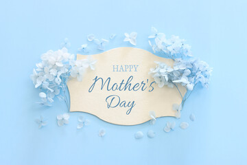 mother's day concept with blue flowers over pastel background