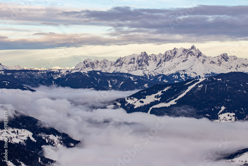 Beautiful winter landscape with snow-capped mountains in the clouds