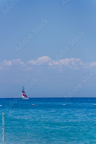 A lonely yacht with bright sails in the Mediterranean Sea on the coast of Turkey in clear calm weather