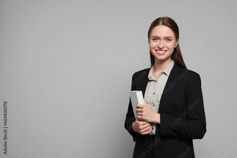 Portrait of beautiful young teacher on grey background. Space for text Portrait of beautiful young teacher on grey background. Space for text