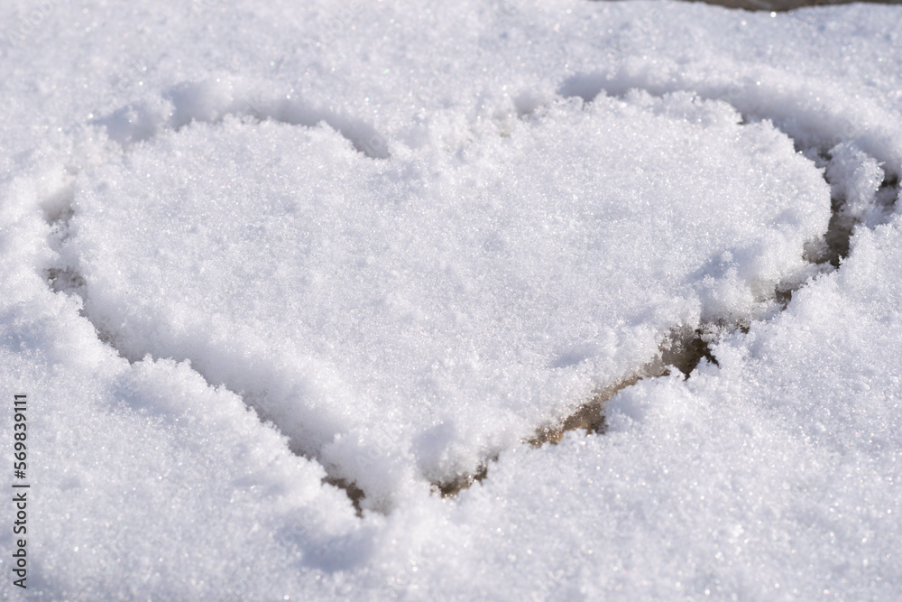Heart outlined on snow, symbol of love, snow background