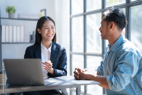 Pointing laptop, Meeting and consulting agenda of indian asia mixed race business man and female china half thai ethnicity bookkeepers discussing balance sheet, stock market profit with yearly tax.