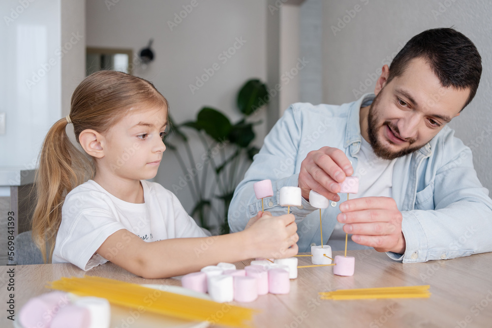 Child girl with father make model of molecule at home. child learning chemistry, engineering and STEM. Child girl with father make model of molecule at home. child learning chemistry, engineering and STEM.