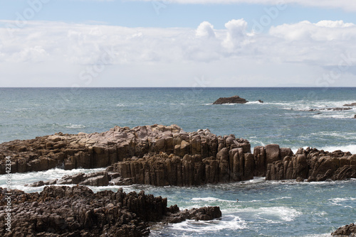 Seascape with rocks and blue sea in a sunny day, near Mangawhai Heads, Auckland, New Zealand. © daisy_y