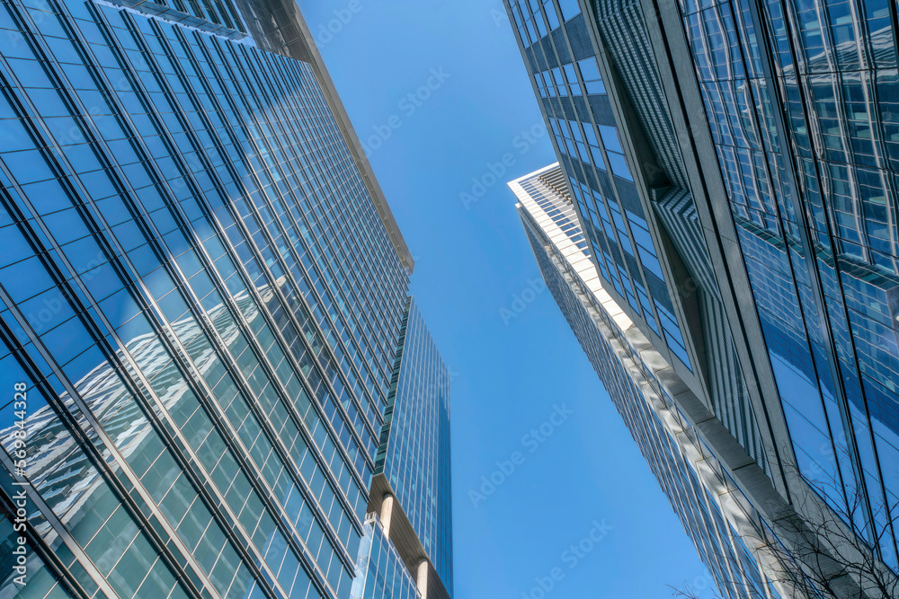 Austin, Texas- High-rise buildings with reflective glass exterior. Two modern buildings across each other with a clear blue sky background in the middle.