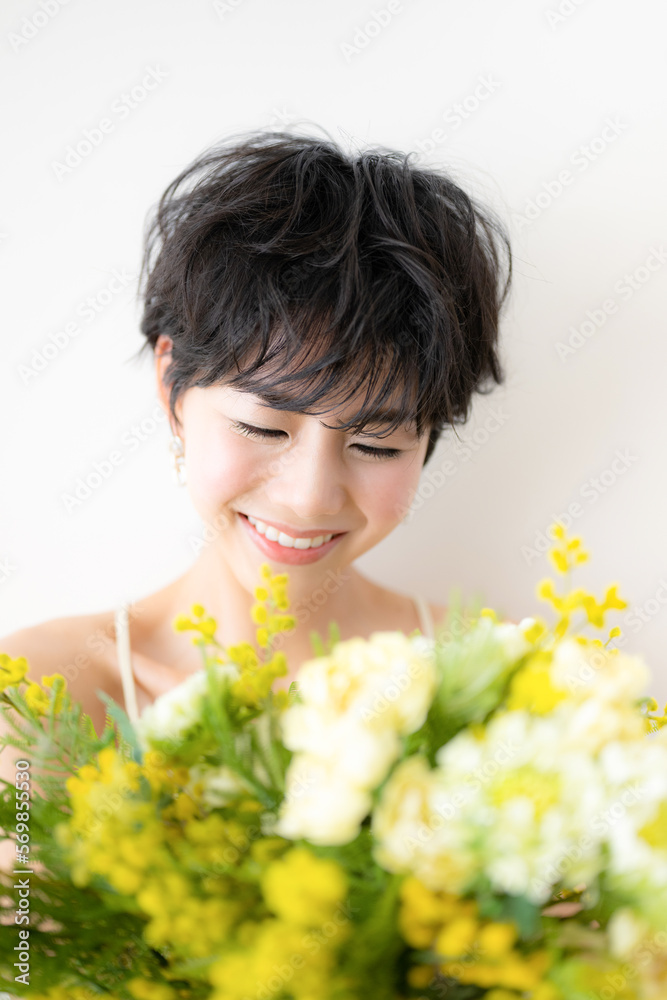 ウェディングや前撮り美容イメージに使えそうなミモザの花束を抱える可愛らしい女性
