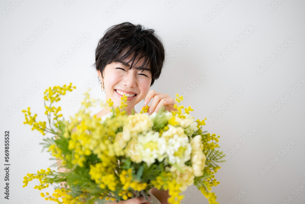 Pretty Asian woman holding a bouquet of happy mimosa flowers. Pretty Asian woman holding a bouquet of happy mimosa flowers.
