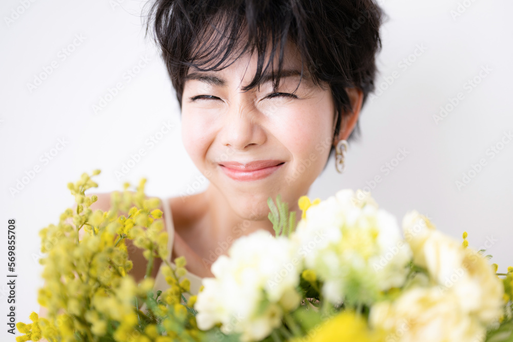 Pretty Asian woman holding a bouquet of happy mimosa flowers. Pretty Asian woman holding a bouquet of happy mimosa flowers.
