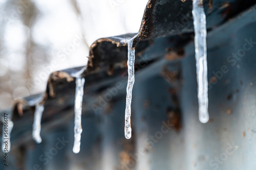 Ice candles protruding from a roof. Cold wave and winter temperatures. © leledaniele