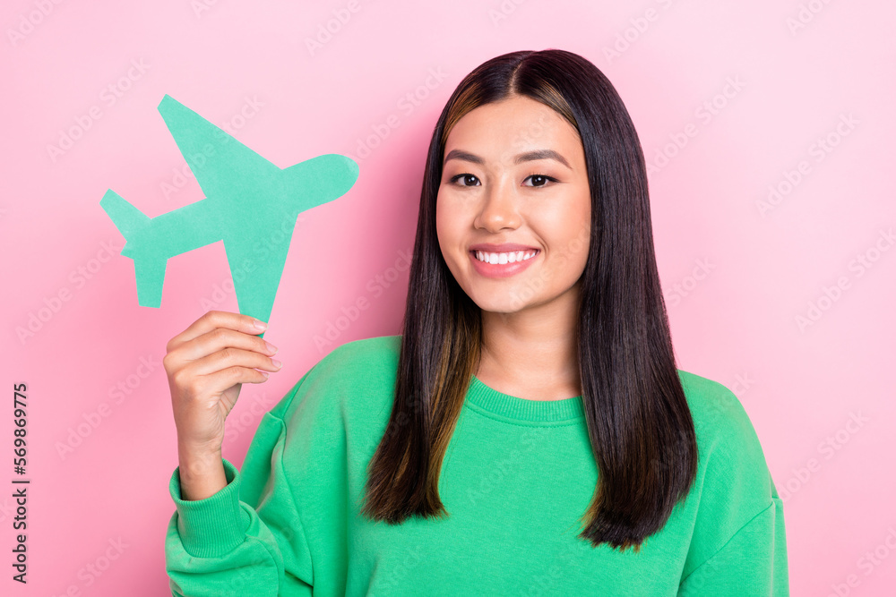Photo of sweet adorable girl dressed green sweatshirt rising paper plane smiling isolated pink color background Photo of sweet adorable girl dressed green sweatshirt rising paper plane smiling isolated pink color background