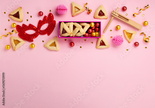 Hamantaschen Cookies, Red Carnival Mask, Noisemaker on Pink Background. Purim Celebration, Jewish Carnival Holiday Concept.