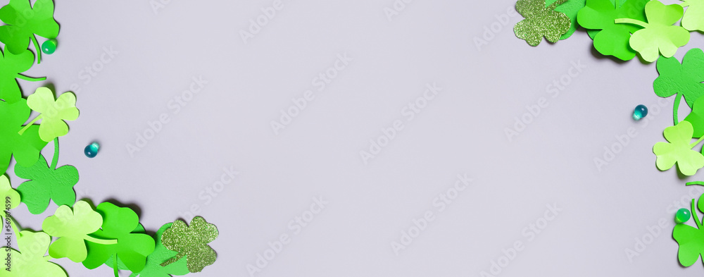 St. Patrick's Day minimalistic banner background. Paper clover leaves on grey background with copy space St. Patrick's Day minimalistic banner background. Paper clover leaves on grey background with copy space