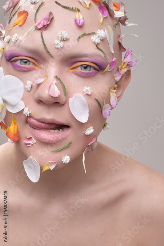 A beautiful woman without hair with flowers on her head, a conceptual photo with an unusual model