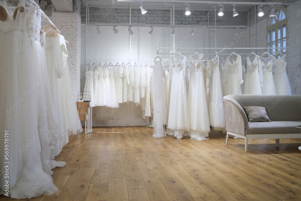 Different wedding dresses on hangers in boutique Different wedding dresses on hangers in boutique