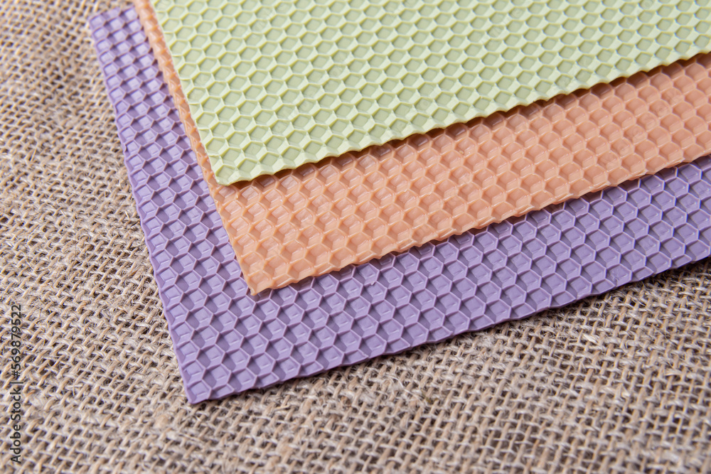 Fototapeta premium Colored wax sheets for candle making on burlap background. Soft focus
