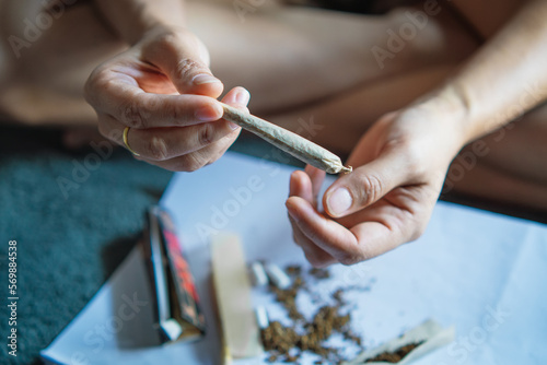 women cannabis holding a roll joint of marijuana in the room ,Drugs narcotic concept. Legal Marijuana. © kasarp