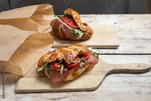 Croissant with jamon, cheese, salad and tomatoes for breakfast photo