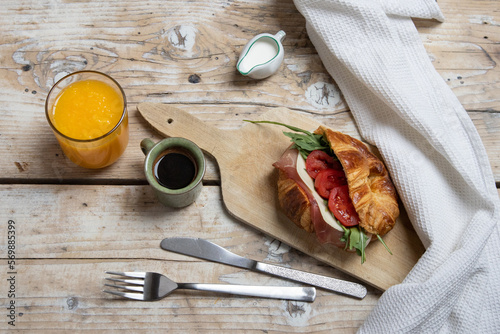 Croissant with jamon, cheese, salad and tomatoes for breakfast photo