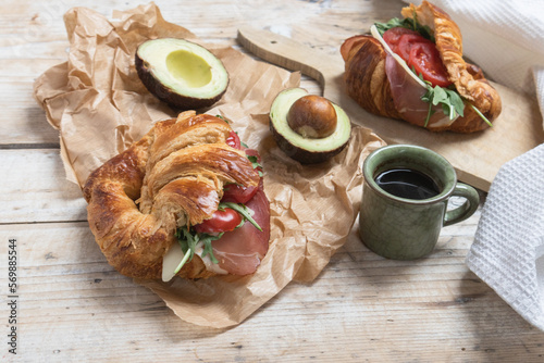 Croissant with jamon, cheese, salad and tomatoes for breakfast