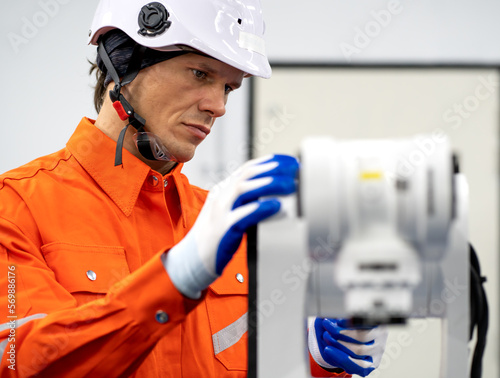 Robotic engineer examining robot power gear machine for repairing service. Modern technology technician working on hardware maintenance to repair steel and metal part of industrial automated equipment