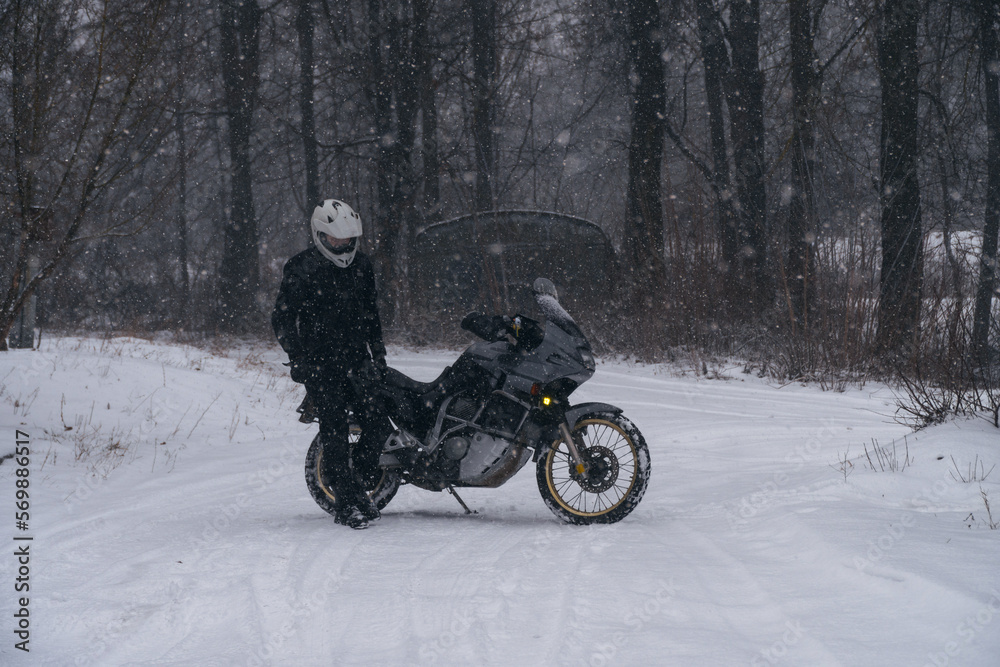 Rider man and adventure motorcycle. Winter fun. snowy day. the snow fall. off road dual sport crazy extreme ride, active life style concept. winter clothes, equipment Rider man and adventure motorcycle. Winter fun. snowy day. the snow fall. off road dual sport crazy extreme ride, active life style concept. winter clothes, equipment