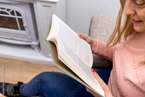 Education learning concept. World Book Day. Reading at home. Close-up of a young blonde woman smiling reading a book.