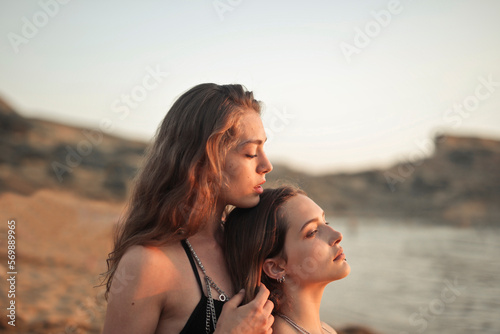 portrait of two girls at the beach embracing