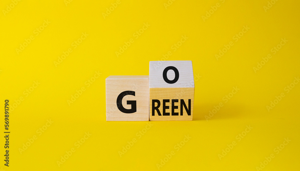 Go green symbol. Turned wooden cubes with words Go Green. Beautiful yellow background. Ecological and Business and Go green concept. Copy space Go green symbol. Turned wooden cubes with words Go Green. Beautiful yellow background. Ecological and Business and Go green concept. Copy space