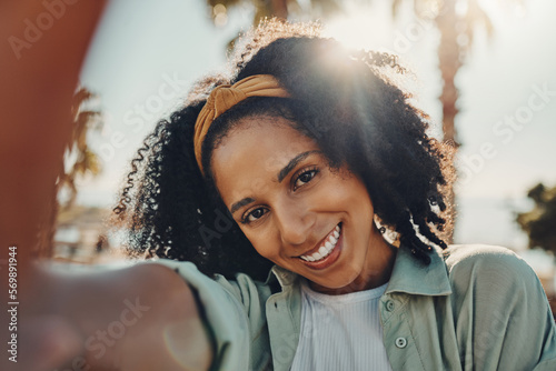 Fototapeta Naklejka Na Ścianę i Meble -  Portrait, selfie smile and happy black woman taking pictures to remember memory, social media or profile picture. Face, beauty and female from South Africa talking photo outdoors in nature or park.