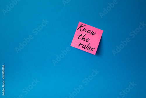 Know the rules symbol. Concept words Know the rules om pink steaky note. Beautiful blue background. Business and Know the rules concept. Copy space. photo